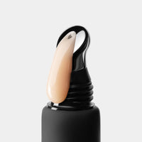 Black bottle with beige cream on a white background