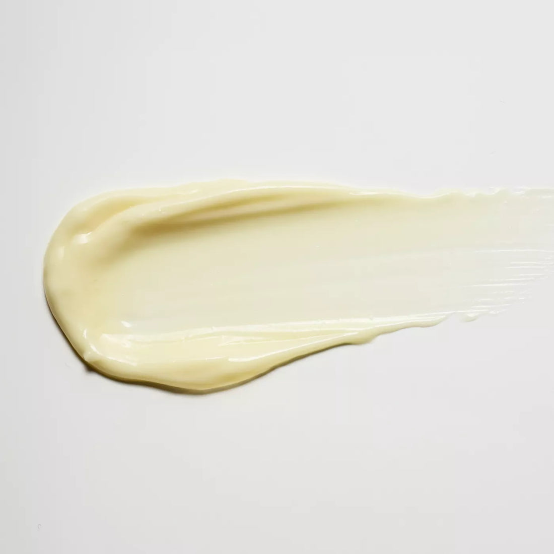 A thick, creamy swatch of pale yellow cream or lotion smeared horizontally on a plain white background.