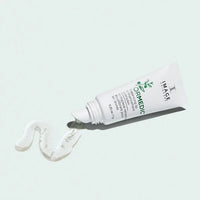 A white tube of IMAGE skincare lip treatment cream with green text, shown lying on its side with a dollop of white cream in front, against a pale mint green background.