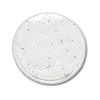 A round, clear plastic tub filled with a translucent white gel  with small blue dots, shown from a top-down view on a white background.