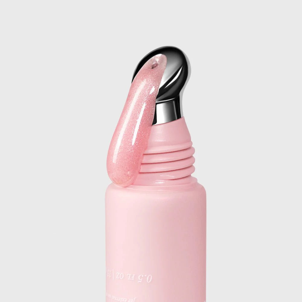 Pink shimmer lip gloss with a metallic nozzle on a light gray background