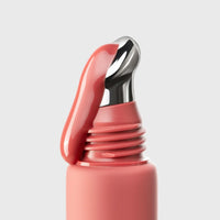 Close-up of a warm pink red lip gloss on a light gray background