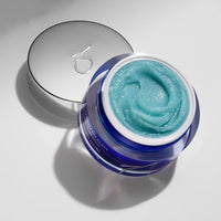 Blue polish in a jar with a silver lid on a light gray background