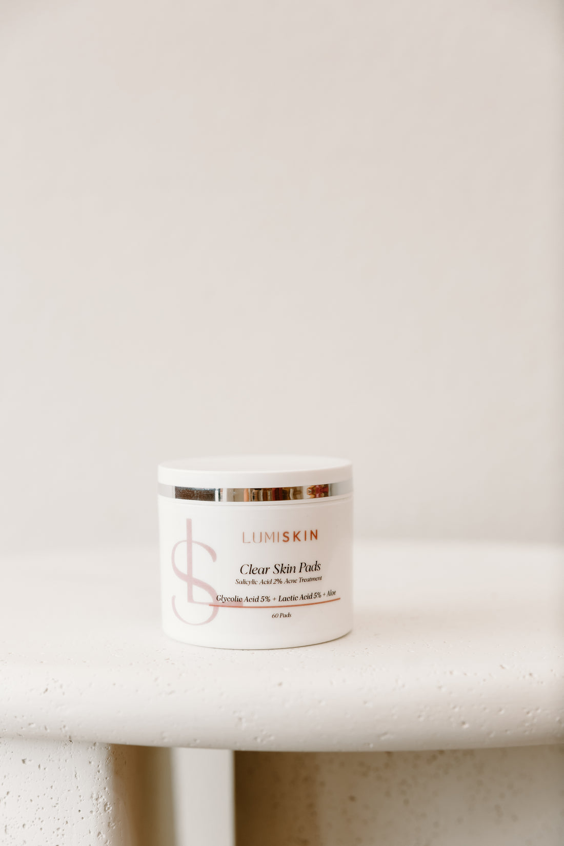LUMISKIN Clear Skin Pads on a white table in front of a white wall